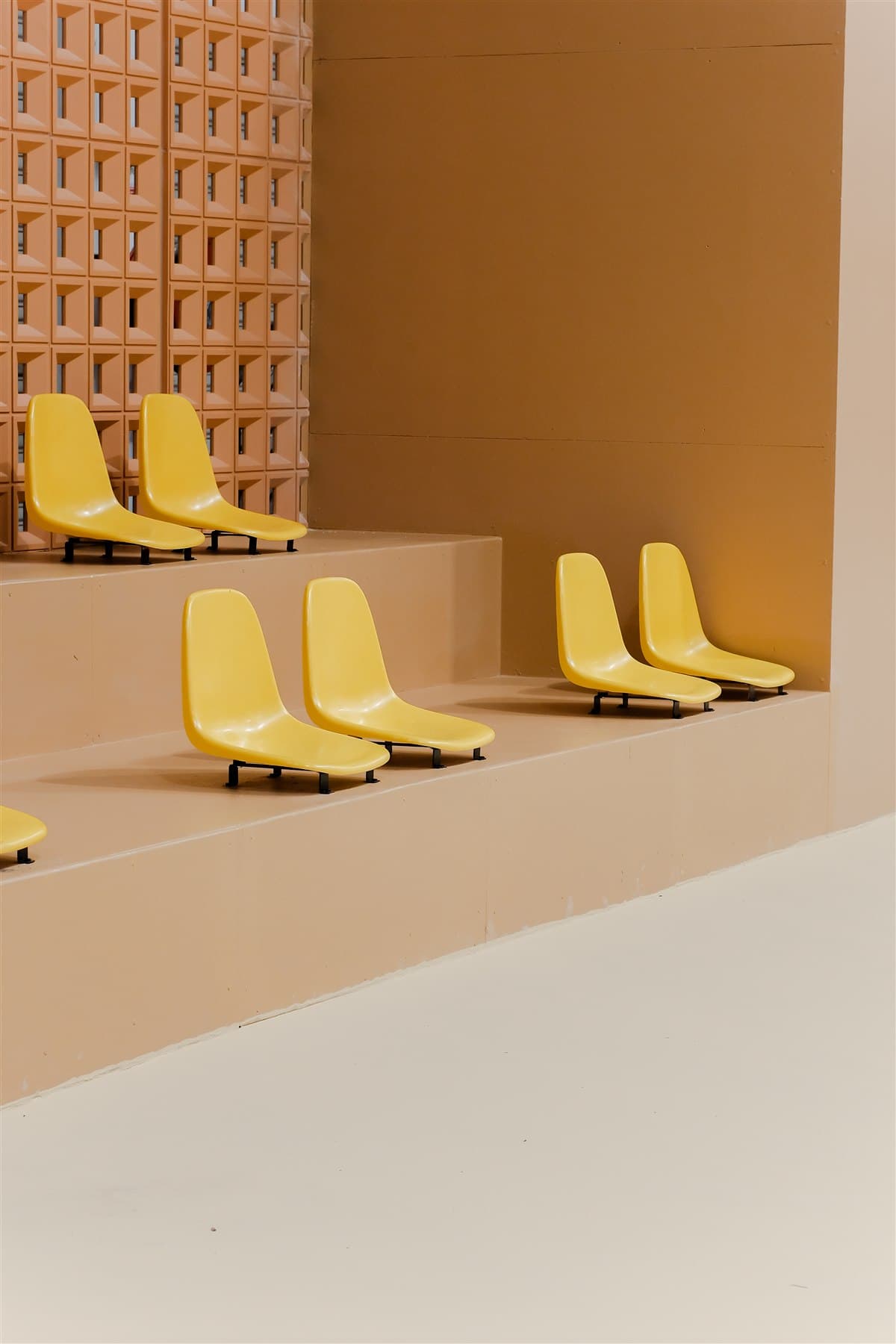Yellow stadium seating along the court-side wall at Pickleland